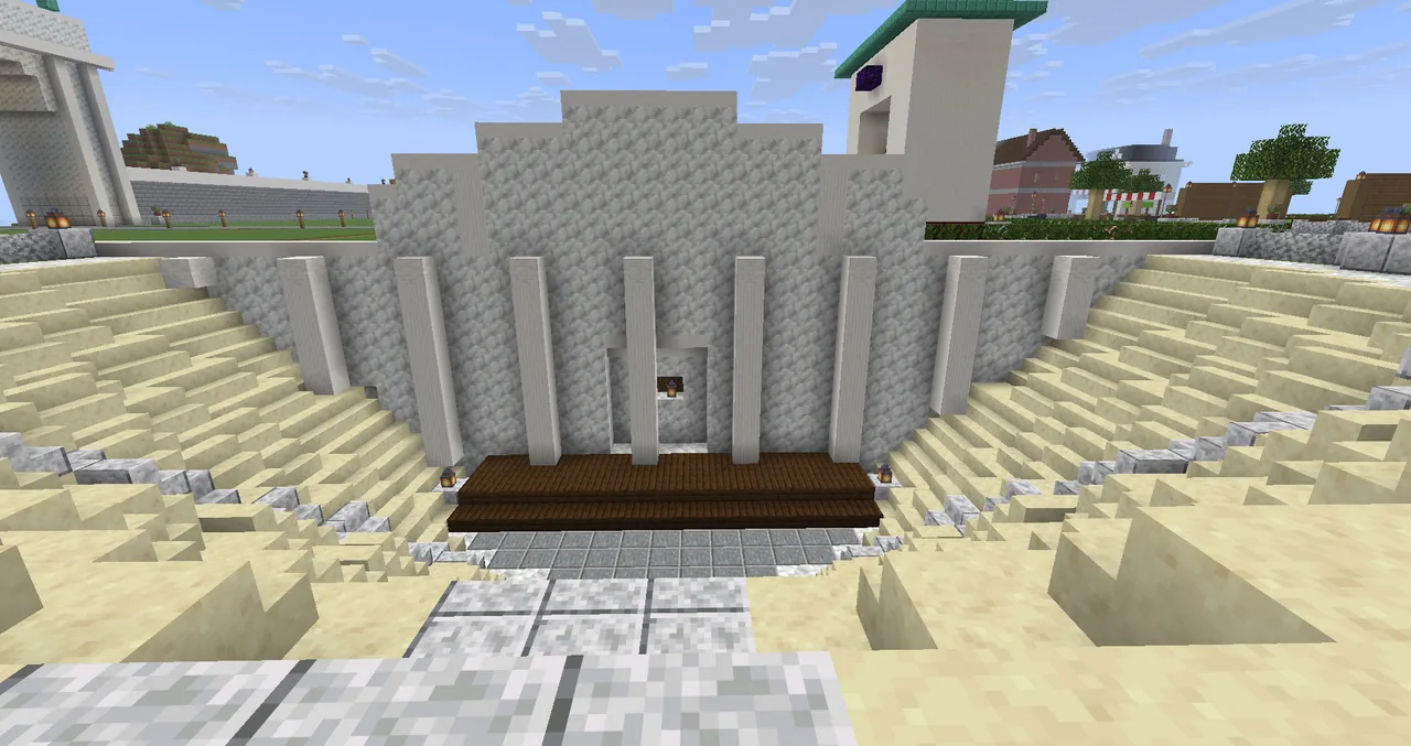 The open-air theatre: stone seats in a half-circle around a wooden stage.